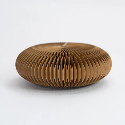 Brown origami honeycomb paper footstool on a white background