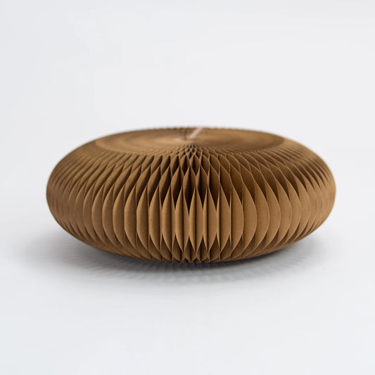 Brown origami honeycomb paper footstool on a white background