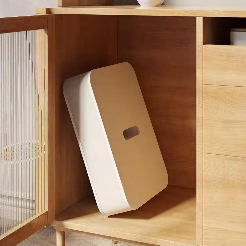 Compressed flat-pack paper bench stored in wooden cabinet between uses