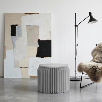 Gray foldable paper stool in a minimalist interior