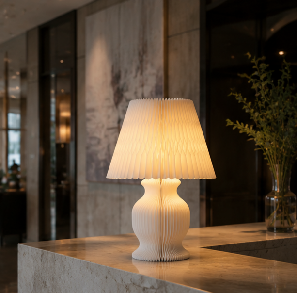 White pleated honeycomb paper table lamp providing warm ambient lighting for hospitality boutique interiors