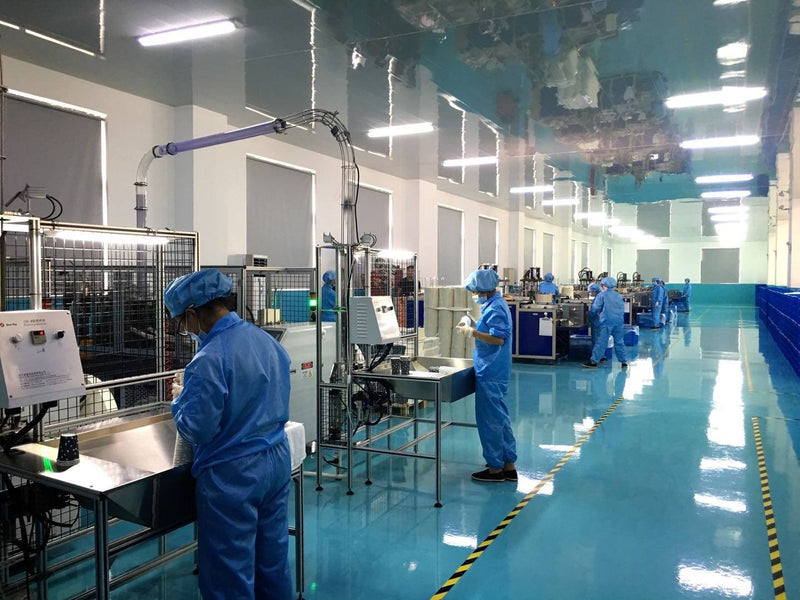 Workers operating paper product manufacturing equipment
