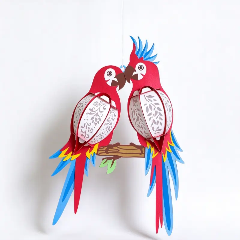 Illuminated lovebird parrot paper hanging lantern with warm decorative cutout panels